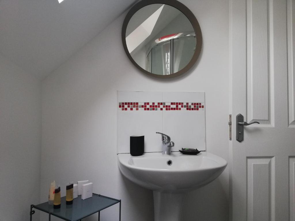 łazienka z umywalką i lustrem na ścianie w obiekcie The Loft at 522 w mieście Woodburn