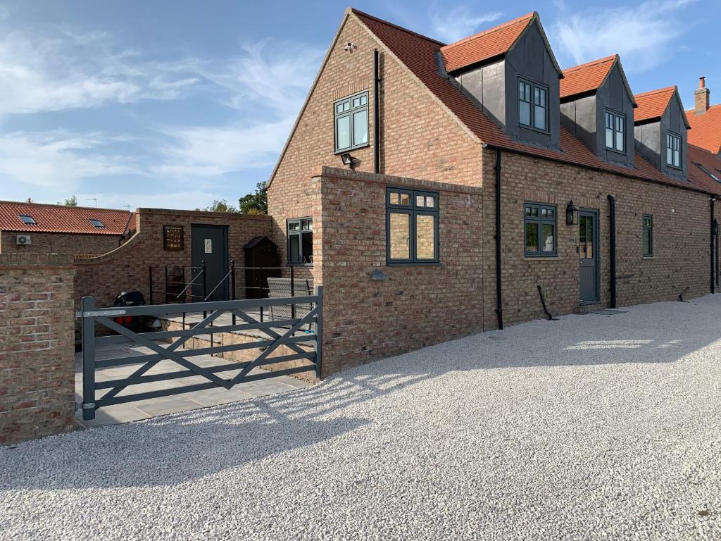 une vue extérieure d'un bâtiment en briques avec une porte dans l'établissement Jenson Cottage, à Skirpenbeck