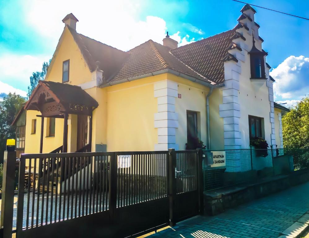 ein gelbes und weißes Haus mit einem schwarzen Zaun in der Unterkunft Apartmán v Zahradní in Prachatice