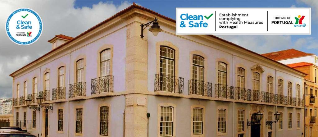 un gran edificio blanco con un cartel que dice caridad y venta en Palácio SantAnna, en Lisboa