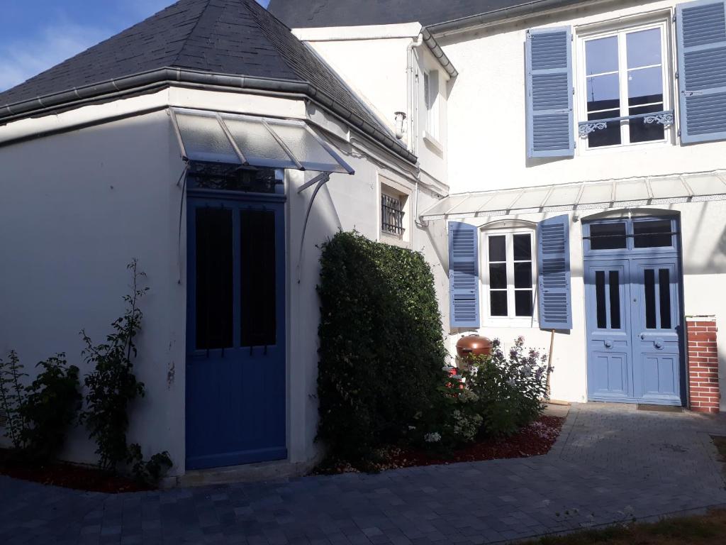 a white house with blue shutters and a blue door at Les Pierres Bleues in Bar-sur-Aube