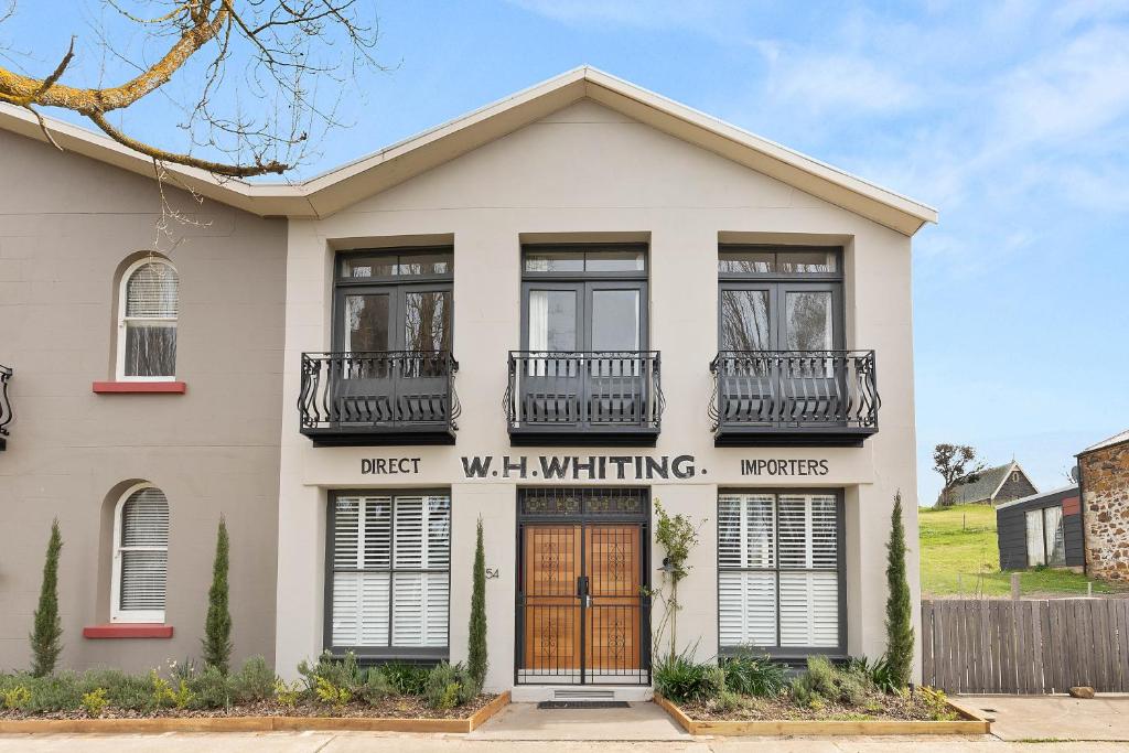 a white house with windows and a door at TARALGA TERRACES The Whitings Store in Taralga