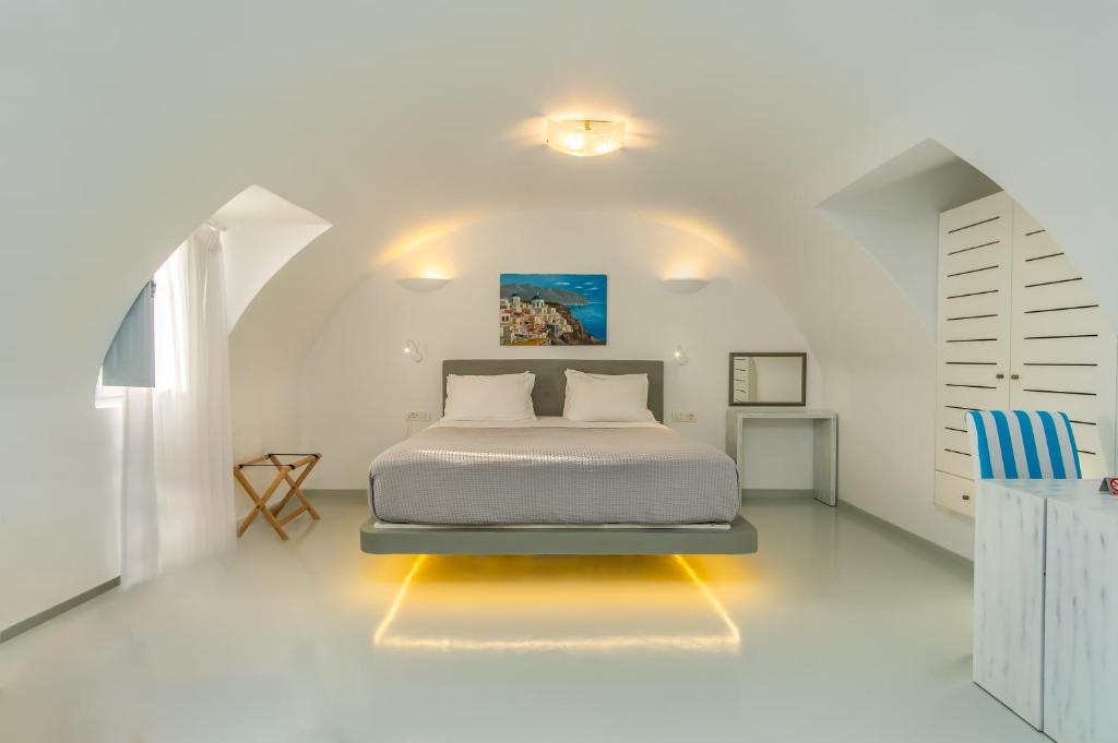 1 dormitorio con 1 cama en una habitación blanca en Central Fira Suites, en Fira