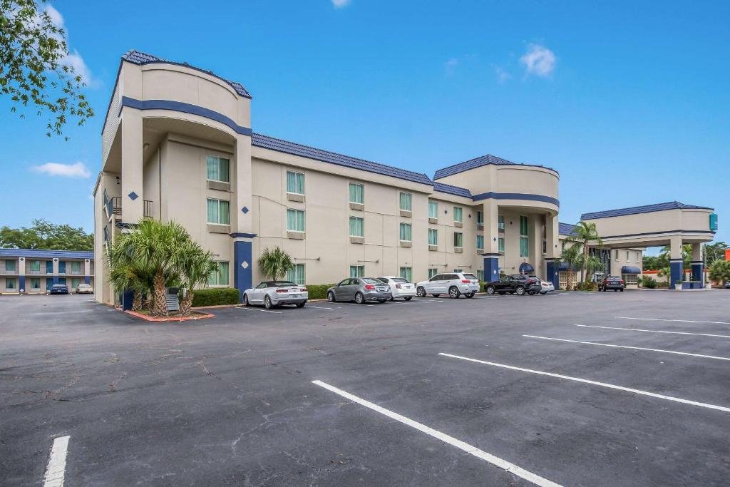 un grand bâtiment avec des voitures garées dans un parking dans l'établissement Clarion Inn & Suites Central Clearwater Beach, à Clearwater