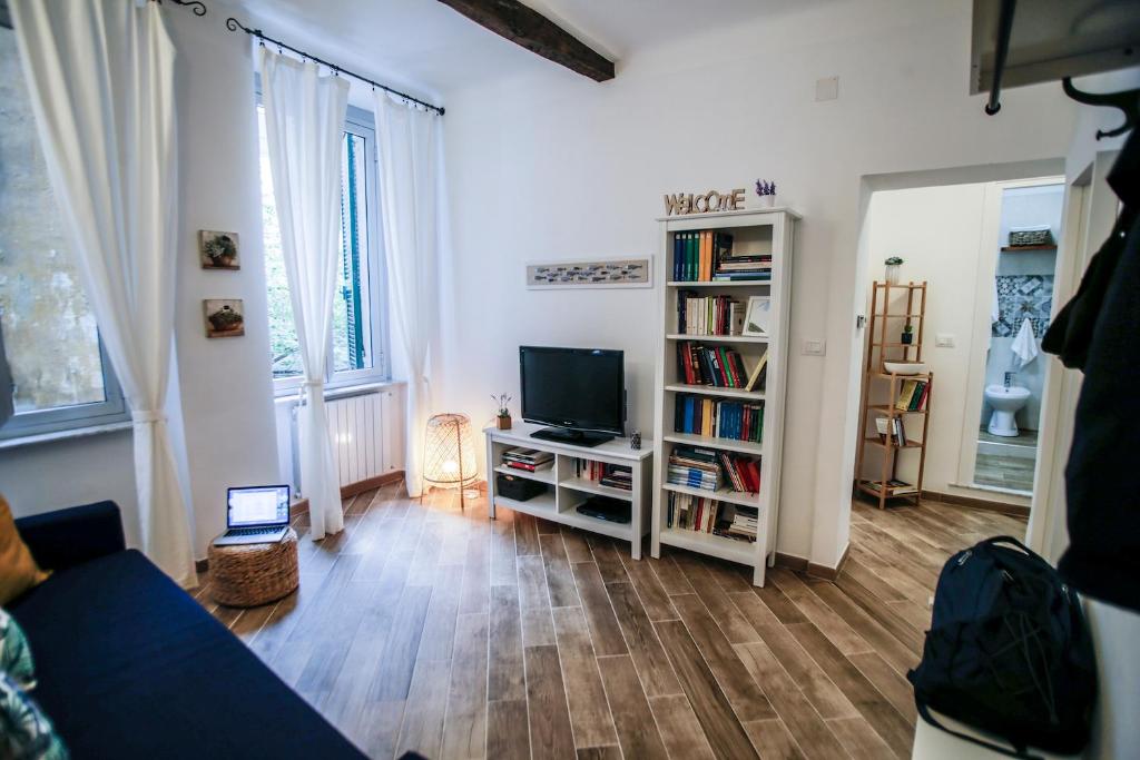 sala de estar con TV y estante de libros en Vivi nel cuore del centro storico di Genova en Génova