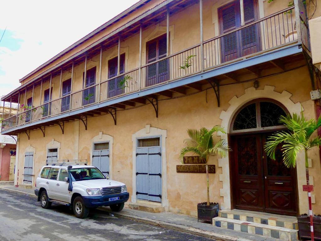 a white suv parked in front of a building at JAMM-La paix in Dar Tout