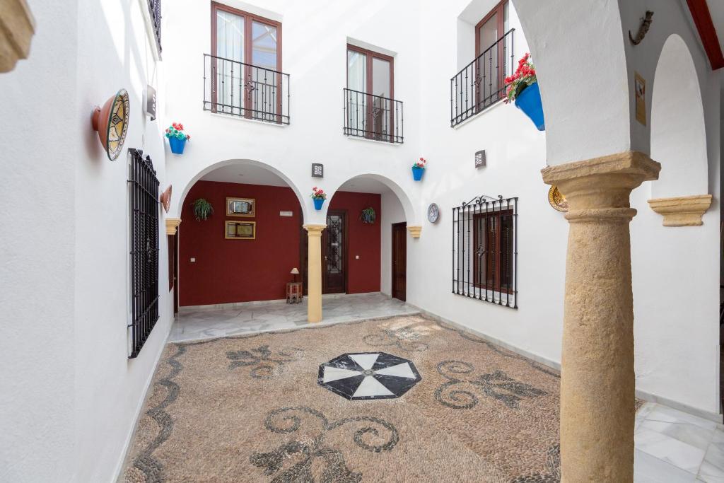 einen Innenhof in einem Haus mit roten und weißen Wänden in der Unterkunft Los Omeyas in Córdoba