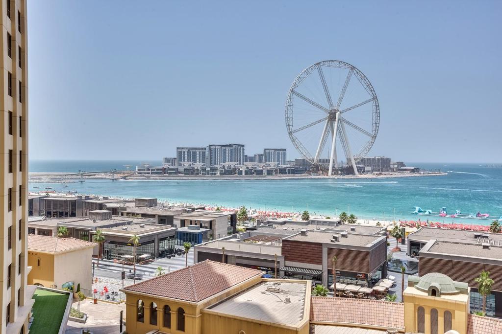 a view of a city with a ferris wheel at Stylish Ain Dubai and Sea View apartment in Dubai