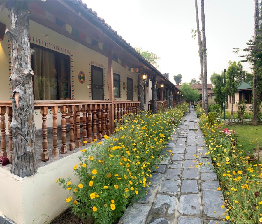 un jardín de flores amarillas junto a un edificio en Jungle Safari Resort, en Sauraha