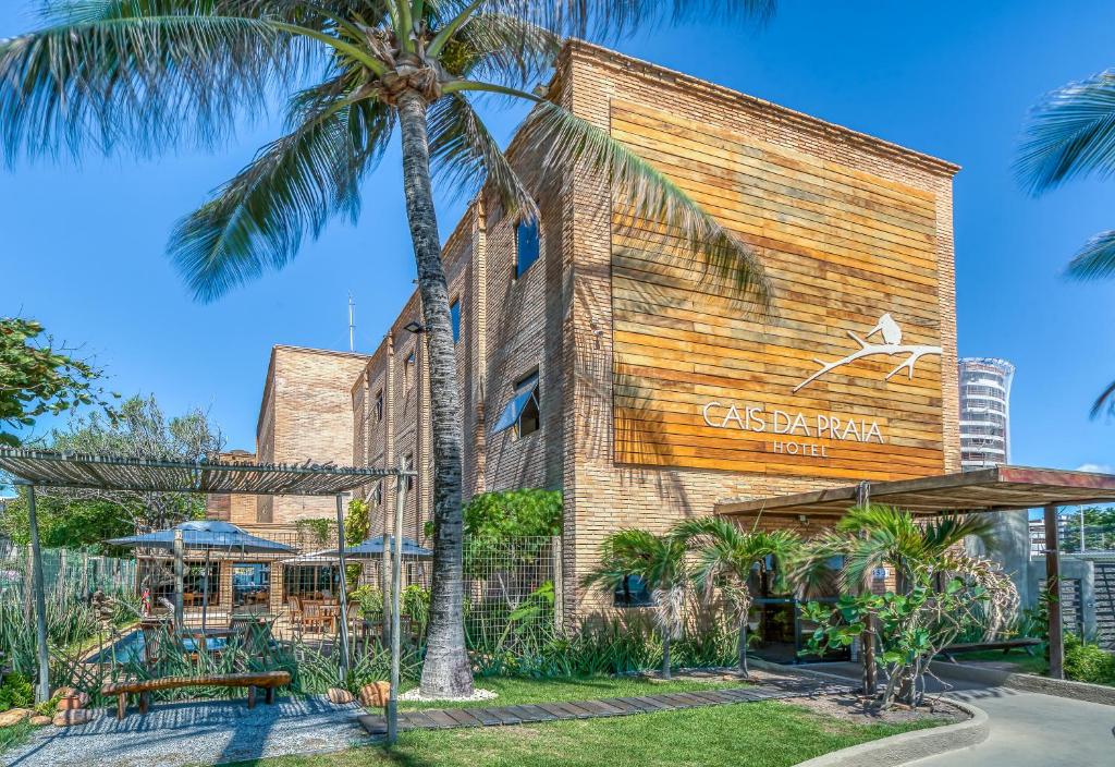 a building with a palm tree in front of it at Cais da Praia Hotel in Maceió