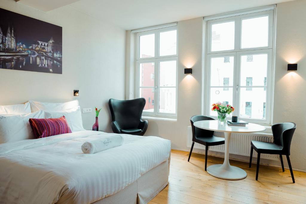 1 dormitorio con 1 cama, mesa y sillas en Heirloom Hotels - The House of Edward en Ghent