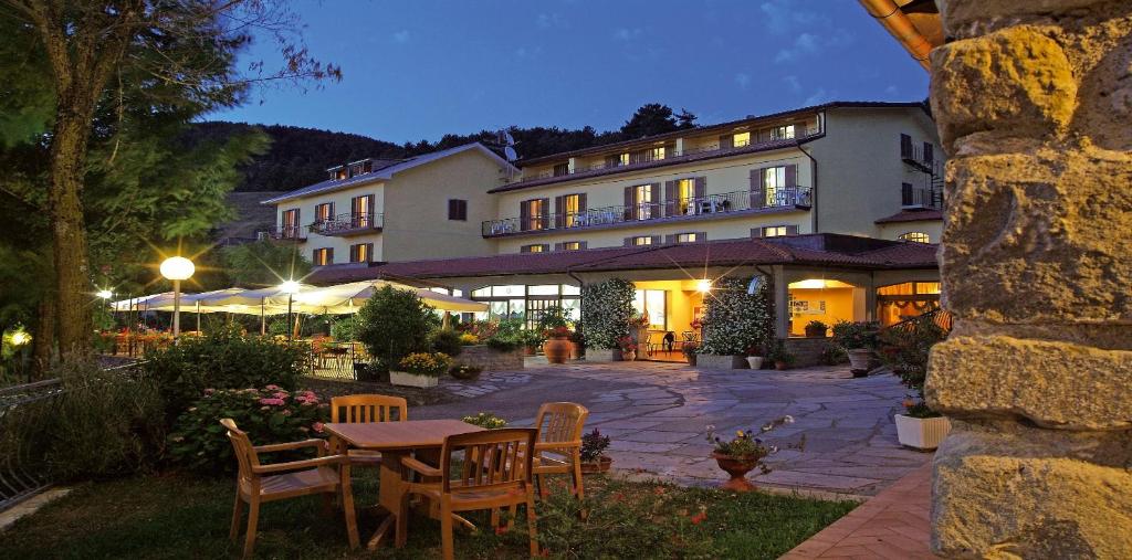 un hotel con una mesa y sillas en un patio en Hotel Belvedere, en Minucciano