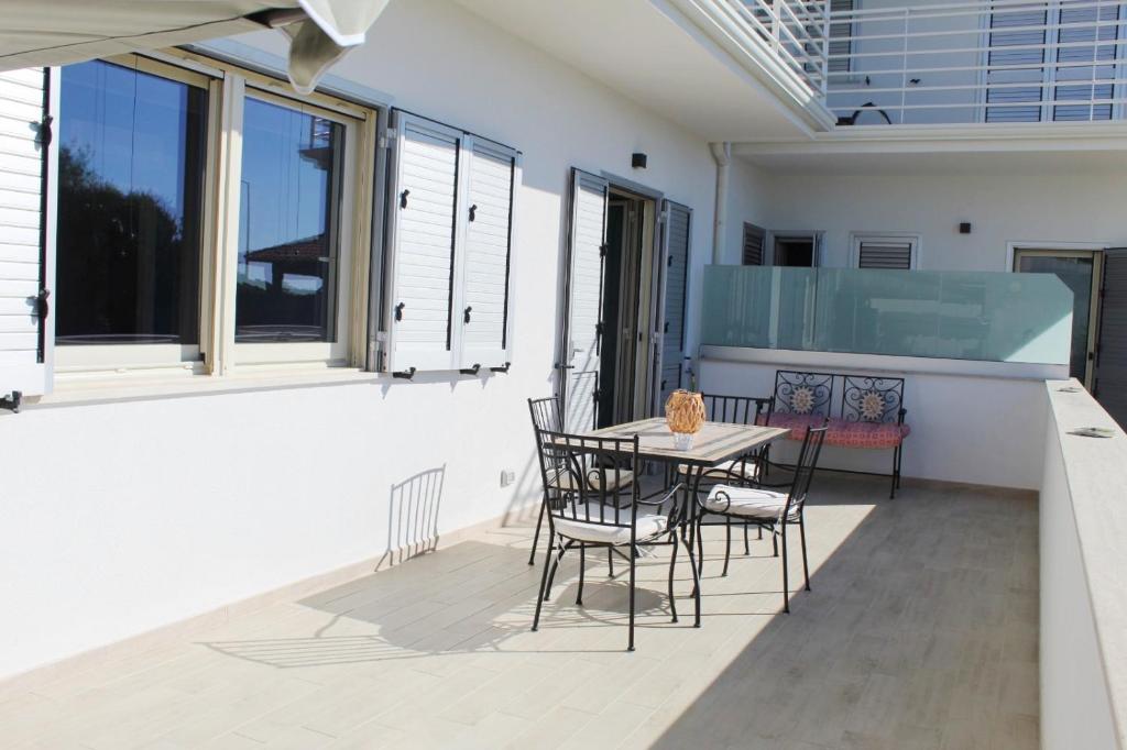 d'une terrasse avec une table et des chaises sur un balcon. dans l'établissement 90 secondi dal letto al mare, à Capo dʼOrlando