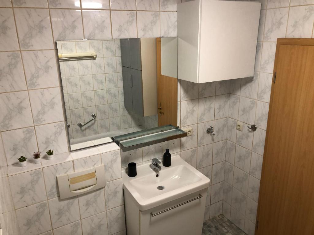 a white bathroom with a sink and a mirror at Pension Miranda in Kelheim