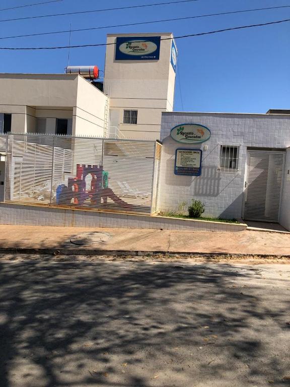 a white building with a fence in front of it at Condomínio Recanto dos Dourados - Casa de Temporada in Três Marias