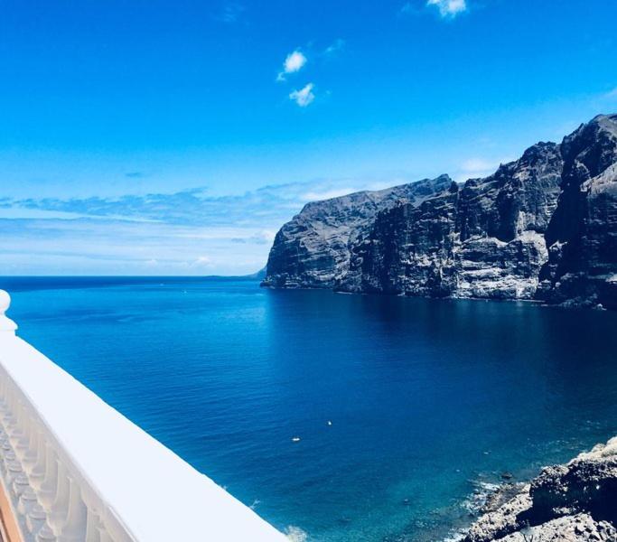 Blick auf einen großen Wasserkörper mit Bergen in der Unterkunft Seaview in Acantilado de los Gigantes