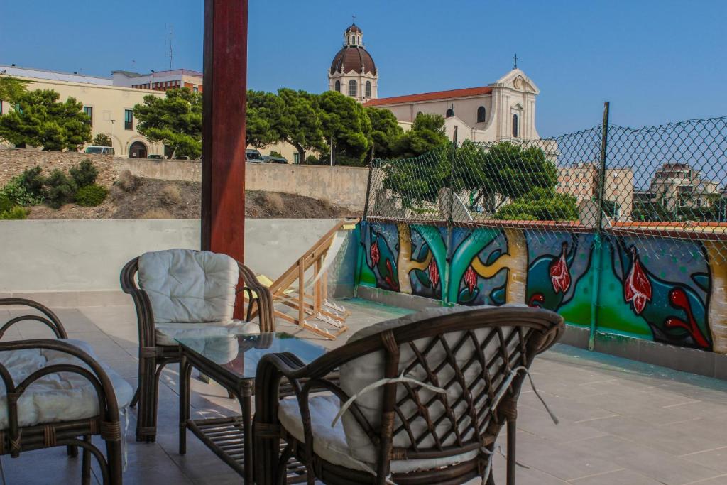 einen Tisch und Stühle auf einer Terrasse mit Wandgemälde in der Unterkunft Attico con terrazza unico in Cagliari