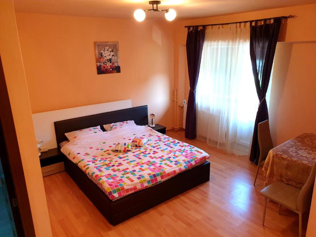 una camera da letto con un letto con un piumone colorato di Central Accommodation Baile Felix a Baile Felix