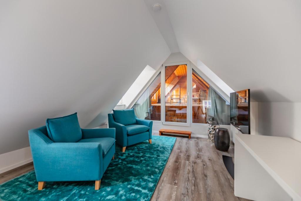 sala de estar con 2 sillas azules y alfombra en Smile Apartments zum Goldenen Strauß, en Dürnstein