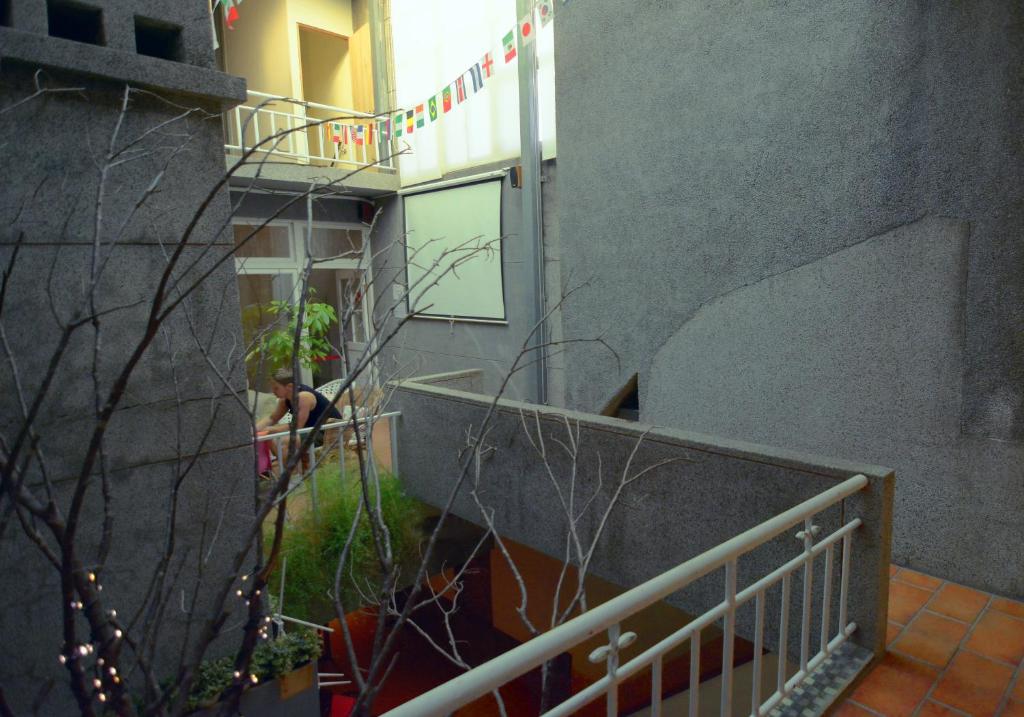 a person standing on a balcony of a building at Happy Taipei Hostel - Share House - Monthly in Taipei