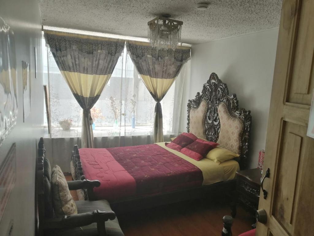 1 dormitorio con 1 cama y una ventana con cortinas en Escocie Quito Colonial, en Quito