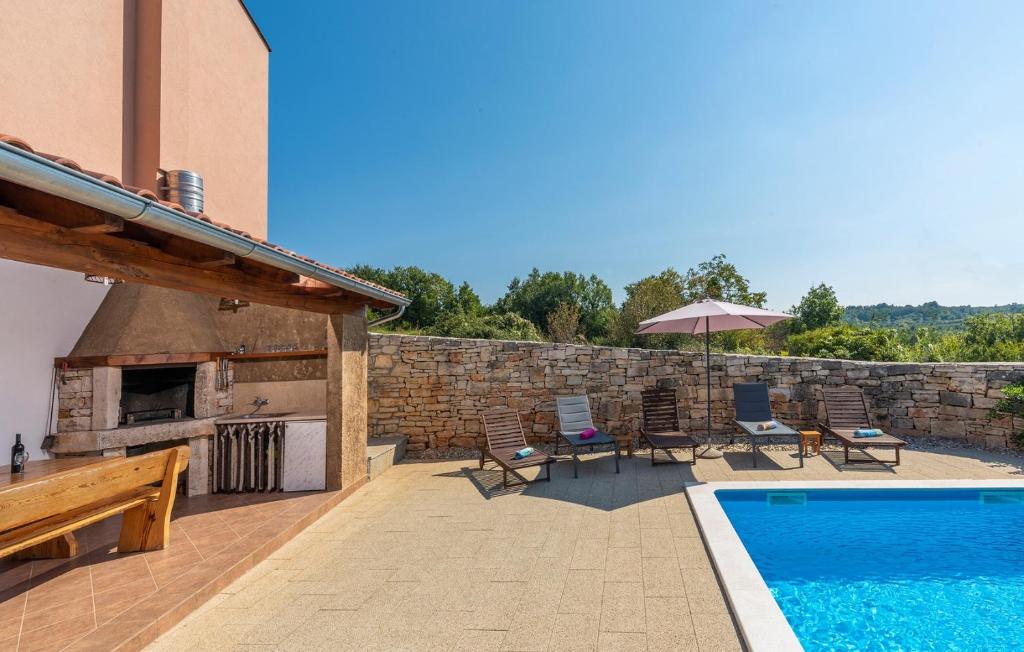 podwórko z basenem i ceglaną ścianą w obiekcie Didova Villa in the Heart of Istria w mieście Jakići
