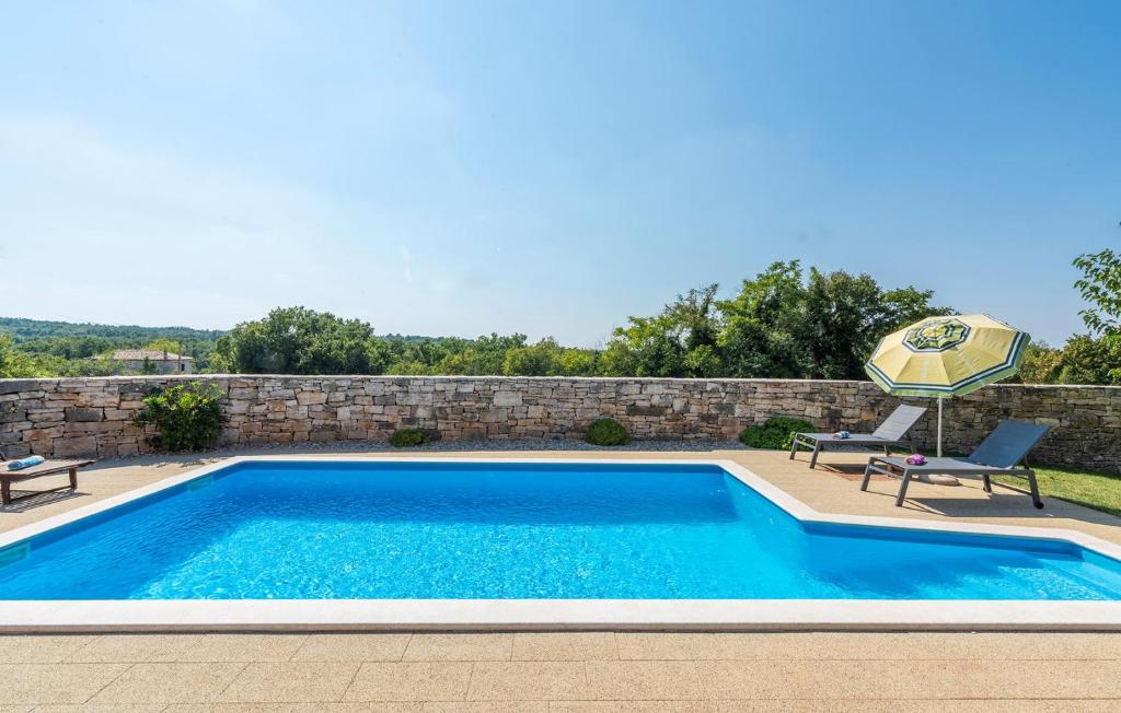 basen z 2 krzesłami i parasolem w obiekcie Didova Villa in the Heart of Istria w mieście Jakići