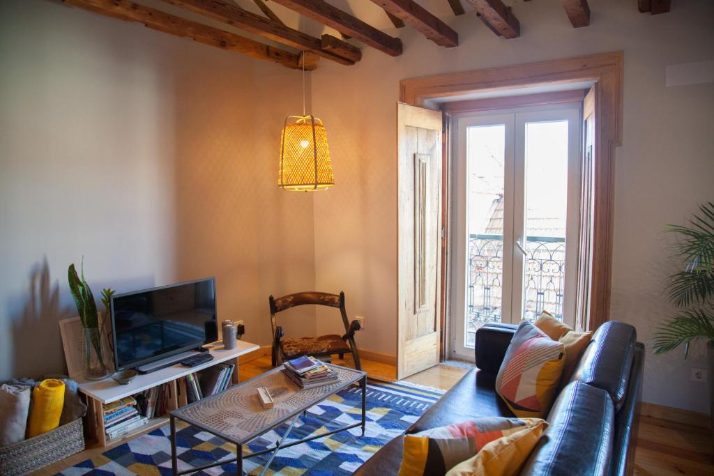 ein Wohnzimmer mit einem Sofa und einem TV in der Unterkunft FLH Duque Mezzanine with View in Lissabon