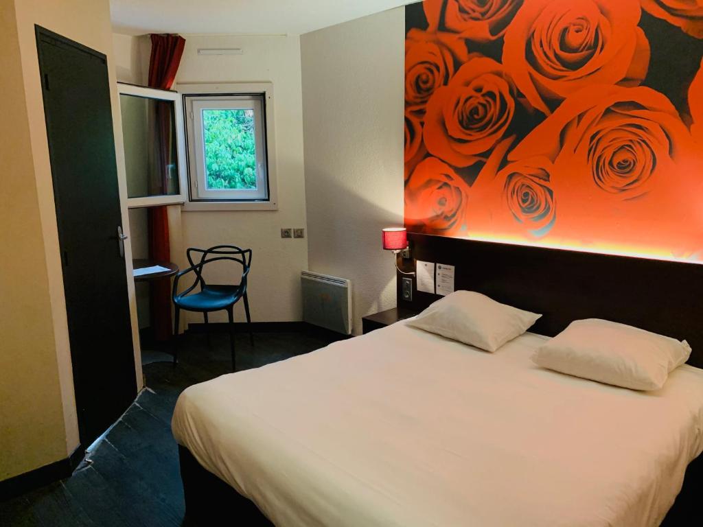 a bedroom with a bed with a painting on the wall at Hotel Inn Design Dijon Sud in Marsannay-la-Côte