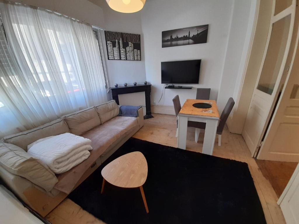 a living room with a couch and a table at Une balade à la plage in Dunkerque