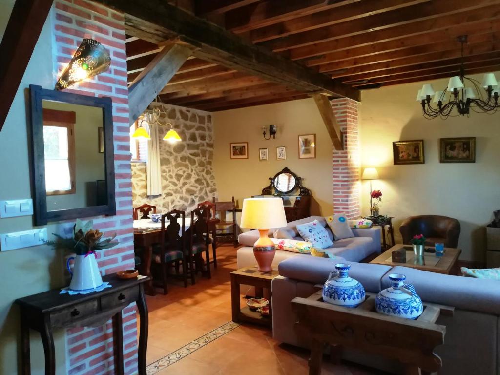 een woonkamer met een bank en een eetkamer bij El Mirador del Gato I y II in Mesegar de Corneja