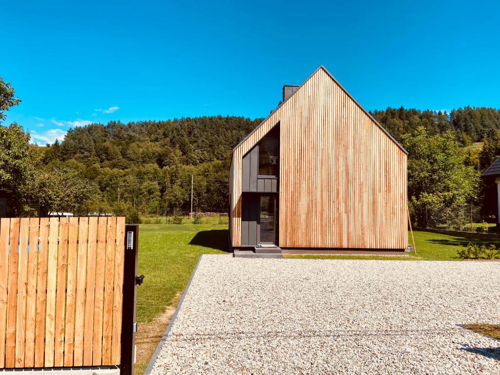 ein Holzhaus mit einem Holzzaun davor in der Unterkunft Pieniny LOVE in Szczawnica