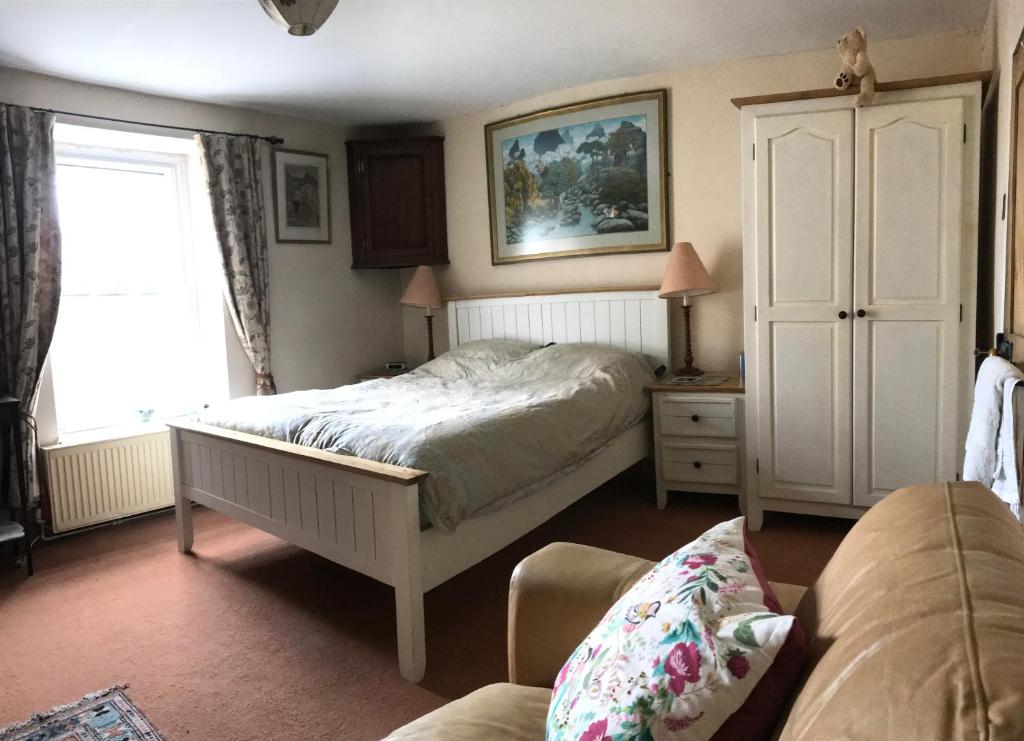 a bedroom with a bed and a chair and a window at Chateau Terrace Georgian House in Chepstow