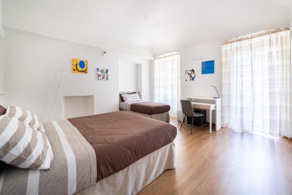 TO.STA BwithoutB HOME SHARING NEL CENTRO DI TORINO في تورينو: غرفة نوم بسرير ومكتب في غرفة