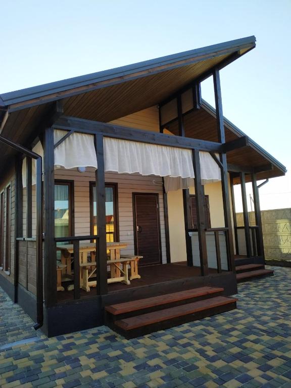 a house with a deck with a picnic table at Дом Дискавери семейный у моря! in Chornomorsk