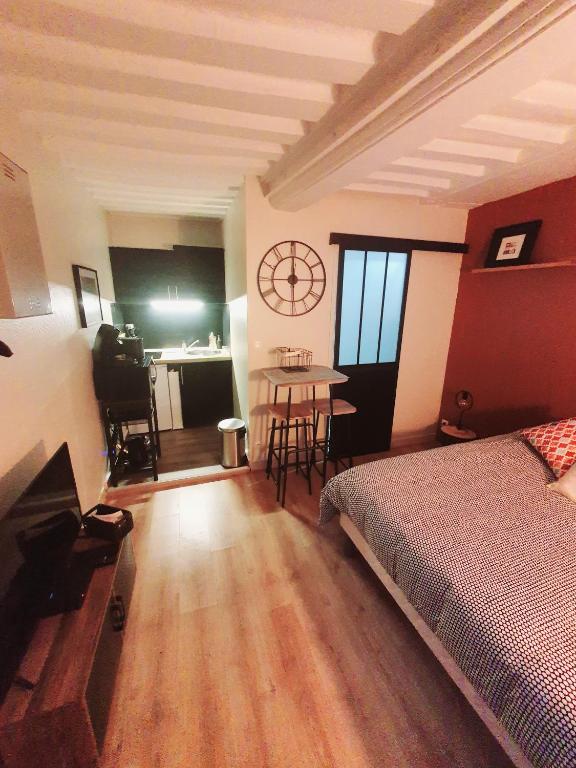 une chambre avec un lit et une table dedans dans l'établissement LE PUITS HONFLEURAIS, à Honfleur