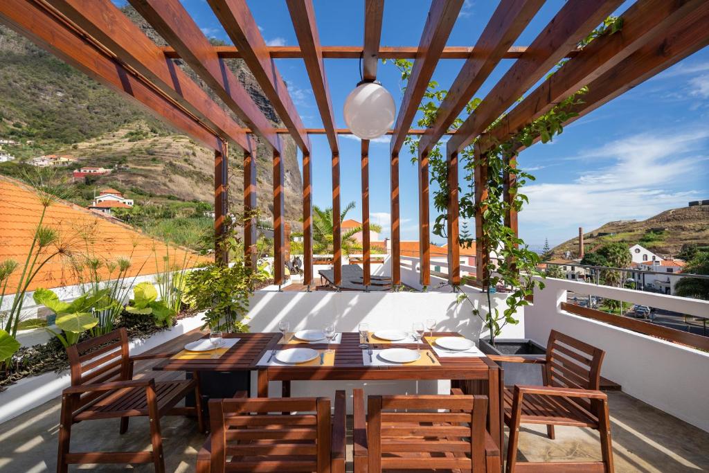 a patio with a table and chairs on a balcony at Madeira Surf Camp in Porto da Cruz