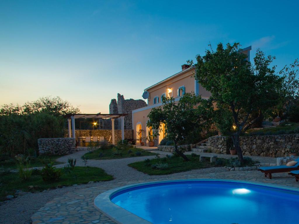 a villa with a swimming pool in front of a house at Villa Cesarica Novalja in Novalja
