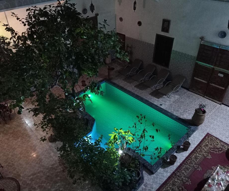 an overhead view of a pool with chairs and plants at Riad Raffaa in Marrakech