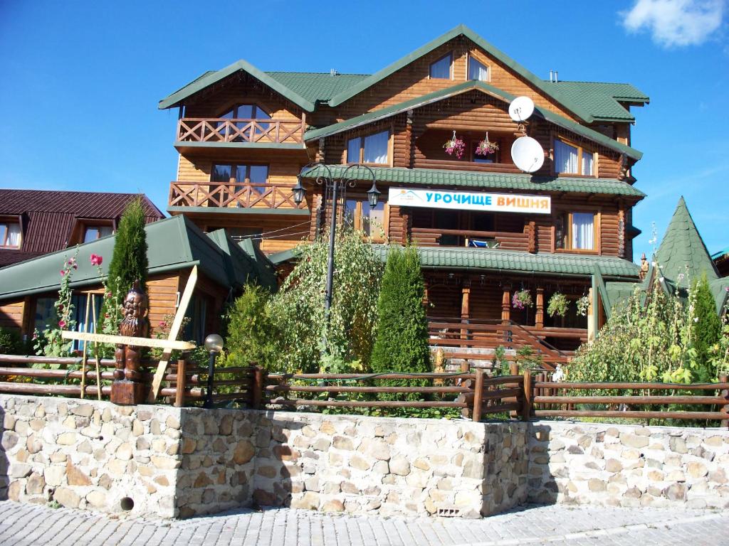 a large wooden building with a sign on it at Urochyshe Vyshnya in Bukovel