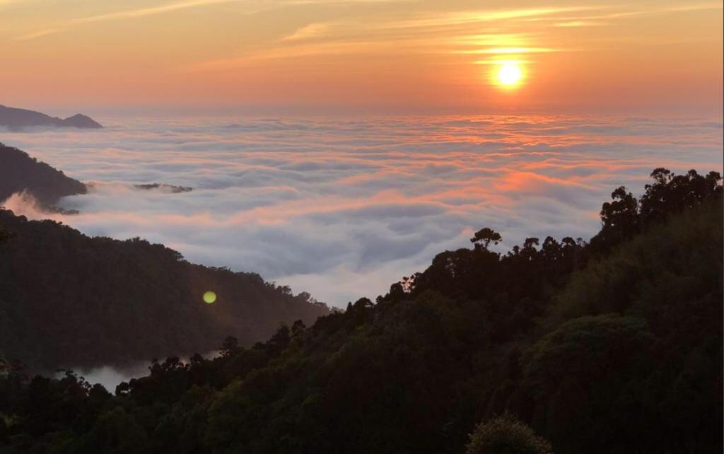 a view of the sun rising above the clouds at Tianyi Homestay in Fenqihu