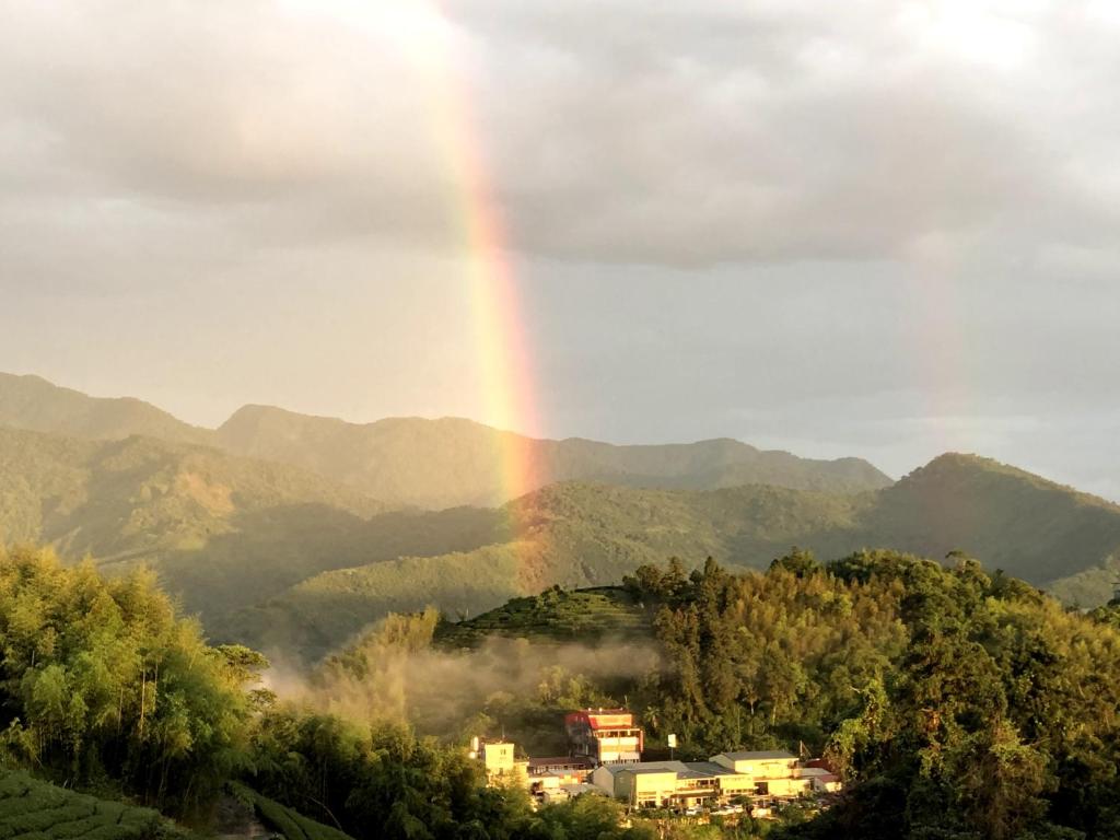 a rainbow in the sky over a mountain at Tianyi Homestay in Fenqihu