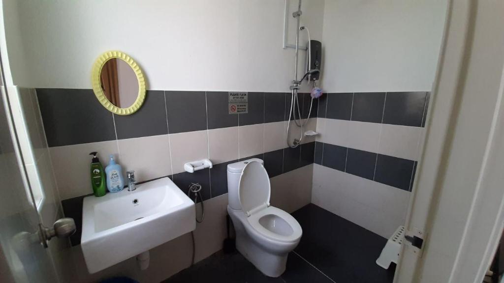 ein Badezimmer mit einem WC, einem Waschbecken und einem Spiegel in der Unterkunft Homestay Greenway in Pasir Gudang