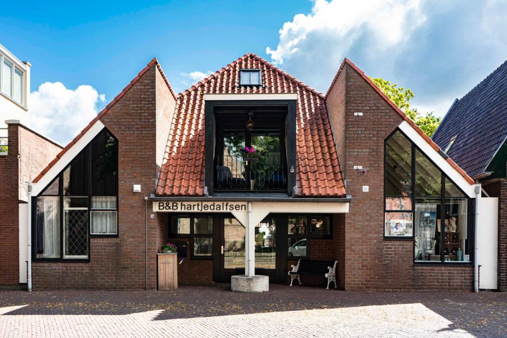 a brick building with a red roof at Hartjedalfsen in Dalfsen