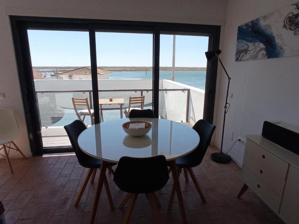 a table and chairs in a room with a view of the ocean at Flamingo Beach House in Santa Luzia