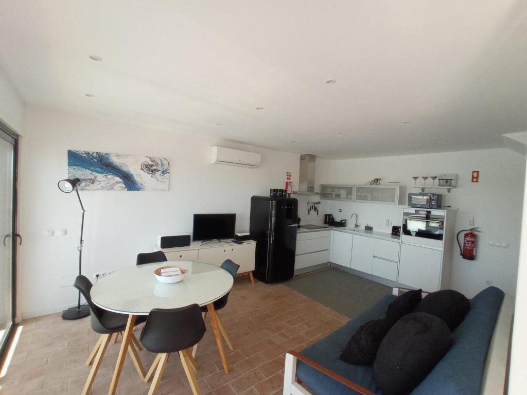 a living room with a couch and a table and a kitchen at Flamingo Beach House in Santa Luzia