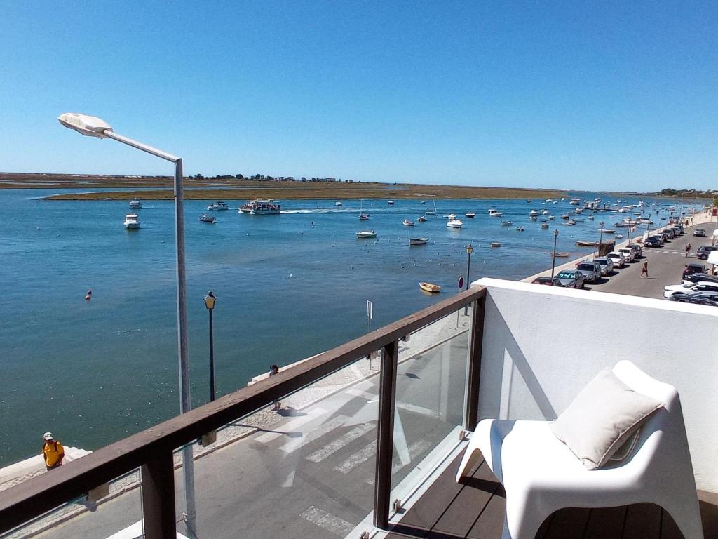a balcony with a view of a harbor with boats in the water at Flamingo Beach House in Santa Luzia