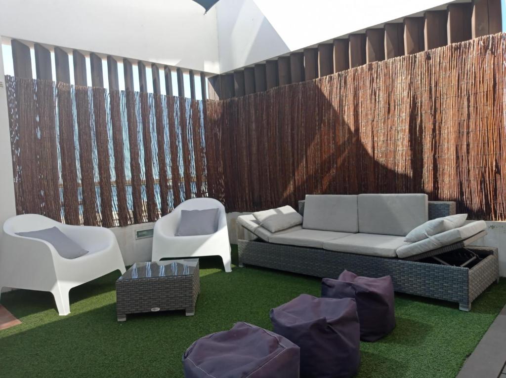a living room with a couch and two chairs at Flamingo Beach House in Santa Luzia