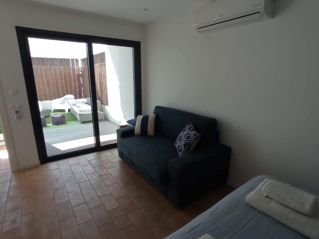 a living room with a blue couch and a sliding glass door at Flamingo Beach House in Santa Luzia