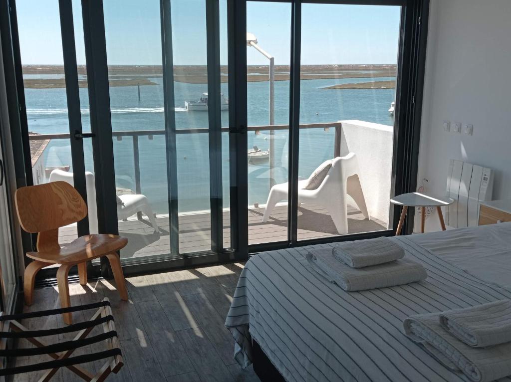 a bedroom with a bed and a view of the ocean at Flamingo Beach House in Santa Luzia